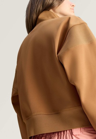 Brauner Sweatshirt mit hohem Kragen, weicher Textur und geripptem Saum. Ausgestattet mit einem lockeren Schnitt und dezenten Nahtdetails.