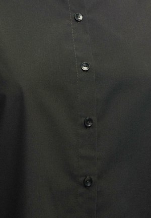 Melnā pogātā krekla krekls, izgatavots no gludas auduma ar asu apdari, ar melnām plastmasas pogām priekšējā daļā aizdarei.