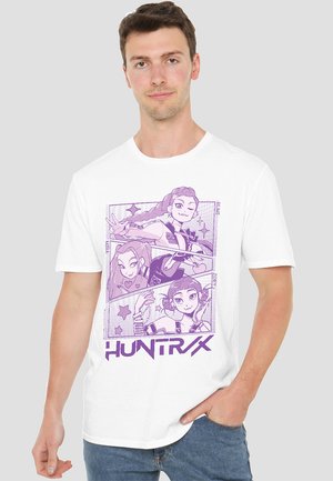 White cotton t-shirt featuring purple graphic illustration of three characters with details and text "HUNTRAX" at the bottom.