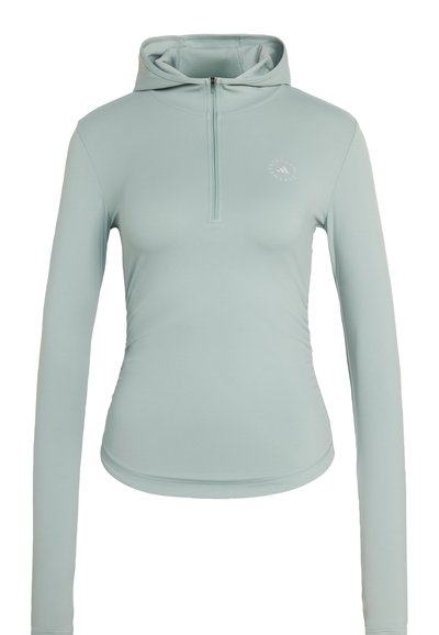 Lyseblå atletisk hættetrøje med lange ærmer, halv lynlås foran og lille cirkulært logo på venstre bryst.
