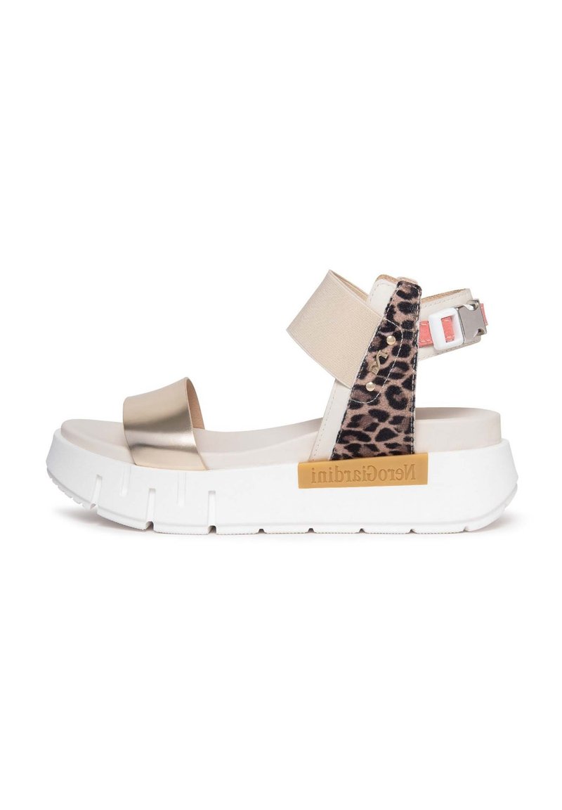 Sandales métalliques dorées et imprimé léopard avec une semelle blanche plateforme. Présente une bride de cheville ajustable et un logo sur le côté.