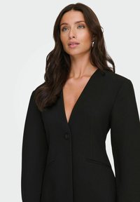 Černý blazer s hlubokým výstřihem do V, zapínáním na jeden knoflík a strukturovanými rameny. Obsahuje boční kapsy a hladký povrch.