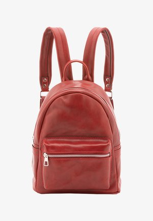 Sac à dos en cuir rouge avec poche zippée à l'avant, bretelles rembourrées ajustables et poignée supérieure sur fond blanc.