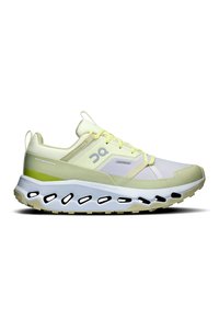 Chaussure de course légère en vert pâle et blanc. Elle possède un dessus respirant, une semelle épaisse et rembourrée, ainsi qu'un design original par découpes pour la ventilation.
