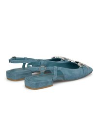 Scarpe slingback in suede blu con punta appuntita, tacco piatto e un'elegante accentuazione argento. Presentano cinturini regolabili e una superficie liscia.