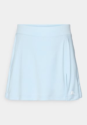 Light blue skort made of stretchy fabric, featuring a flat waistband and pleated details on the sides. White logo accent at the hem.