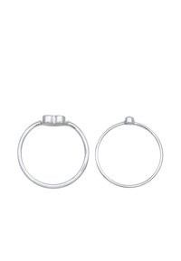 Zwei silberne Ringe in unterschiedlichen Größen, kreisförmig mit glatten Oberflächen und abgerundeten Kanten. Jeder besitzt ein kleines, erhabenes Akzent oben.
