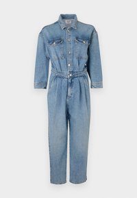 Svetlo modri jeans kombinezon z gumirastnim pasom, gumbom spredaj, dvema žepoma na prsih in dolgimi rokavi za oprijet silhueto.