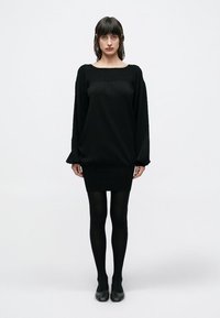 Μαύρο πλεκτό φόρεμα με μακριά μανίκια, στρογγυλή λαιμόκοψη, ριμπ υφή στο μπούστο και εφαρμοστό τελείωμα, συνδυασμένο με αδιαφανή καλσόν.