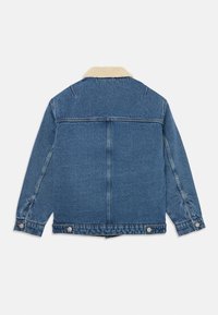 Giacca di jeans con colletto morbido di colore chiaro. Presenta un design classico, maniche lunghe e chiusure con bottoni metallici sui polsini.