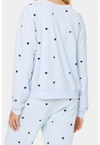 Felpa azzurra con piccoli cuori neri stampati, con polsini e fondo a costine, e una vestibilità comoda. Ideale per un look casual.