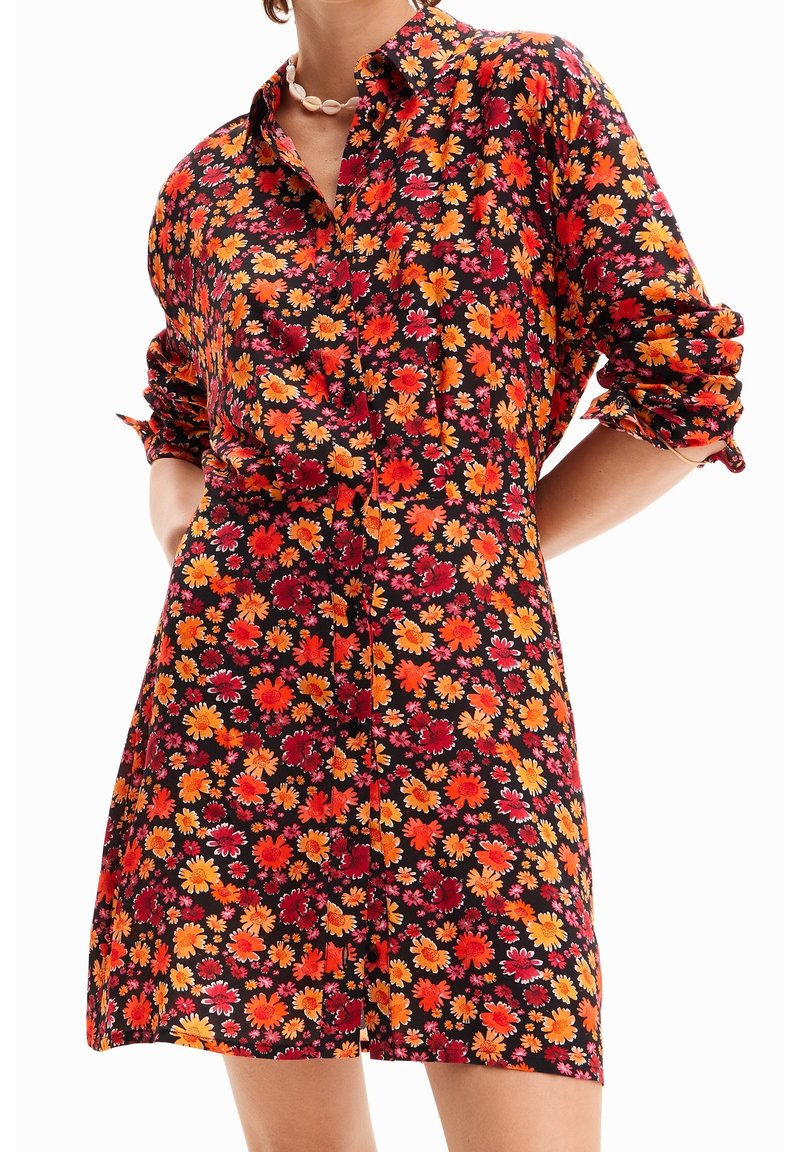 Květinové šaty s tmavým pozadím; obsahují oranžové, červené a růžové květiny. Design na knoflíky, ohrnuté rukávy a volný střih.