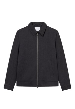 Tummanharmaa takki, joka on valmistettu teksturoidusta kankaasta. Takissa on vetoketjusuljenta, kaulus ja kaksi sivutaskua. Suora malli ilman näkyviä kuvioita.