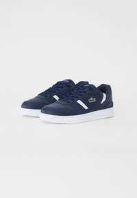 Marineblaue Sneaker mit weißen Akzenten, hergestellt aus glattem synthetischem Material. Verfügt über eine runde Zehenpartie, flache Sohlen und ein kleines gesticktes Logo.