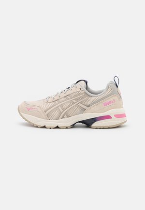 Beige and light pink ASICS 1090 v.2 sneaker with mesh and suede upper, patterned sole, and pull tab on heel.