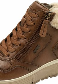 Bottines en cuir marron à mi-hauteur avec un col en fausse fourrure, un design à lacets, un détail de fermeture éclair sur le côté et une semelle en caoutchouc texturé.