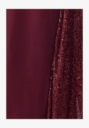 Burgunderrotes Kleid mit glattem Stoff auf der einen Seite und funkelnder Paillettenstruktur auf der anderen Seite, die einen kontrastreichen visuellen Effekt erzeugt.