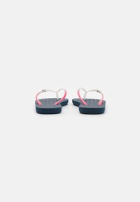 Tongs bleues avec un semelle texturée, straps blanches rehaussées de rose. Design minimaliste, matériau léger, adapté pour un usage décontracté.