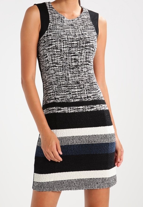 Robe sans manches avec un haut texturé noir et blanc, présentant des rayures horizontales noires, bleues et blanches sur la jupe. Fabriquée en tissu tissé.
