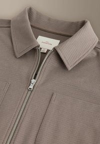 Chemise taupe texturée à fermeture éclair, avec un col pointu et une poche poitrine, de taille moyenne, de la marque Next Signature.