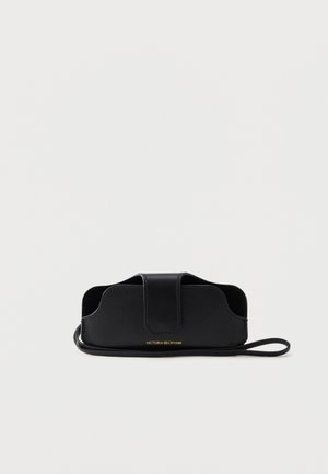 Estuche para gafas de cuero negro con correa para la muñeca y solapa magnética, logo dorado "Victoria Beckham" en la parte inferior central del frente.