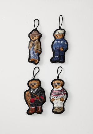 Tikkpaberiga kaunistatud kangast ornaments, kus on kujutatud nelja karu erinevates riietustes: teksariides, talveriided ja svetrid, mis on erksate värvide ja tekstuuridega.