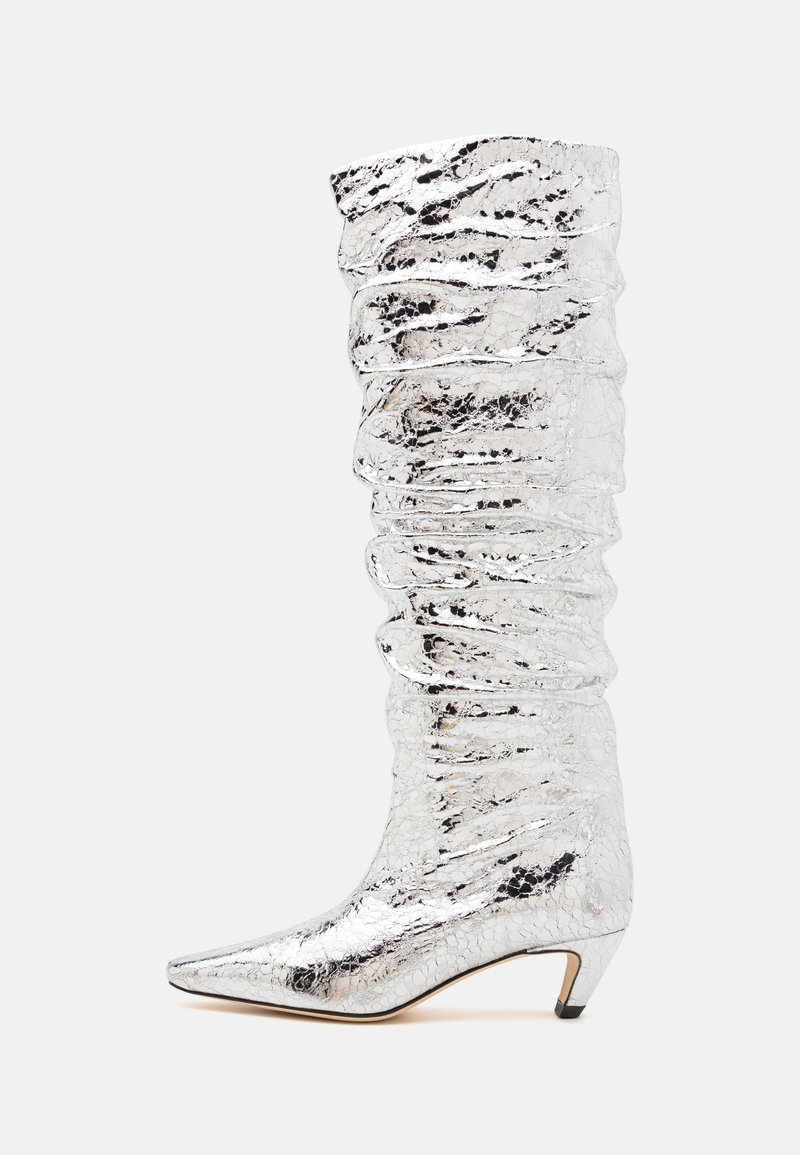 Botte argentée arrivant à mi-mollet avec une texture froissée, un bout pointu et un petit talon. Fabriquée en matériau brillant avec une surface réfléchissante.