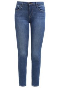 Modré skinny džíny s pěti kapsami, zapínáním na knoflík a jemným vyblednutím na stehnech a kolenou.