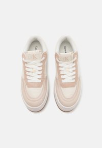Calvin Klein-sneakers har en pastellrosa og hvit design, som kombinerer glatte og teksturerte materialer, med hvite snøringer og en dempet såle.