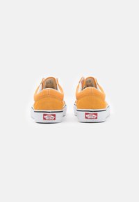 Oranžid sametist slip-on kingad valgete kummist taldaga ja mustade aktsentidega. Omab pehmendatud kaela ja Vansi logo kandadel.