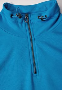 Pullover blu con colletto alto, dotato di mezza zip, cordoncini regolabili e una texture di tessuto liscia e elastica.
