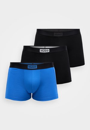 Drei Paare Boxer Shorts der Marke Hugo: ein blaues und zwei schwarze, mit elastischem Bund und Logoetikett, glatte Stoffstruktur.