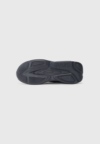 Dark gray shoe sole with a textured rubber surface, featuring defined grooves and brand logo, offering traction and durability.