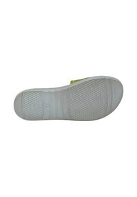 Suola di scarpa bianca con grip testurizzato, caratterizzata da una finitura liscia e un accento verde chiaro. Il design include scanalature orizzontali e motivi circolari.