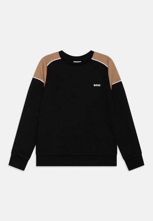Sweat-shirt noir à col rond avec panneaux d'épaule beige et passepoil blanc, arborant un petit logo blanc "BOSS" sur la poitrine gauche.