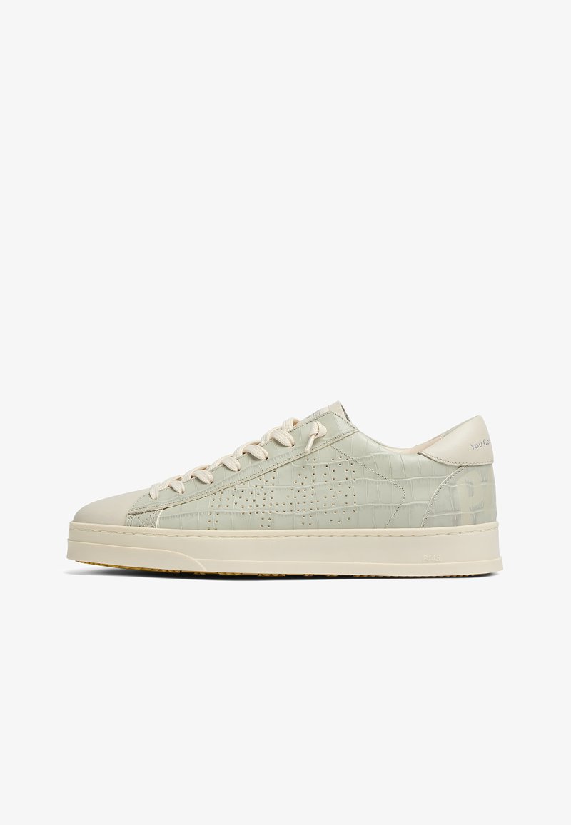 Baskets basses beiges avec motif crocodile texturé, design latéral perforé, fermeture à lacets et semelle épaisse sur fond blanc.