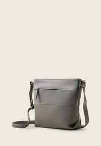 Szara torba crossbody wykonana z teksturowanego materiału syntetycznego, z gładką dolną częścią, przednią kieszenią na zamek i regulowanym paskiem.