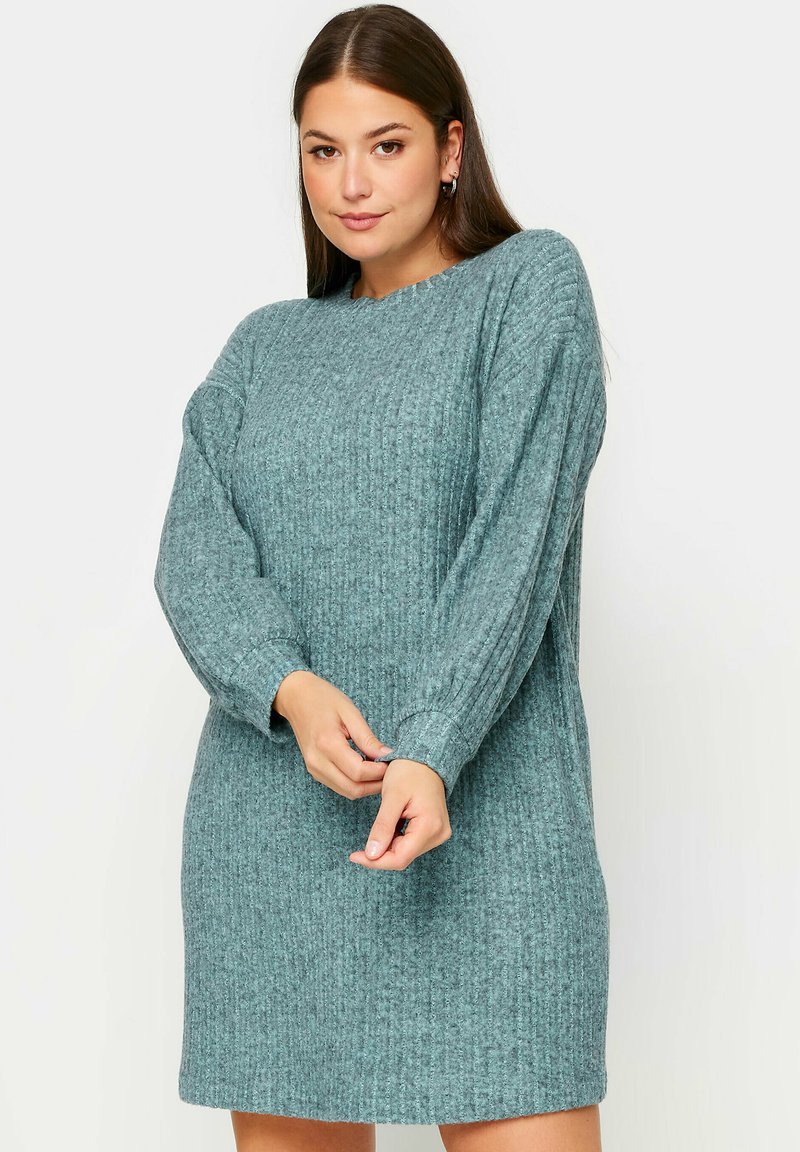 Abito a maniche lunghe in maglia a coste color teal, con vestibilità morbida e scollatura rotonda, maniche leggermente affusolate e tessuto testurizzato.