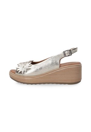 Metallisch zilveren wedge sandalen met een open teen, voorzien van een bloemaccent aan de voorkant en een verstelbare slingbackriem. Textuurzool.