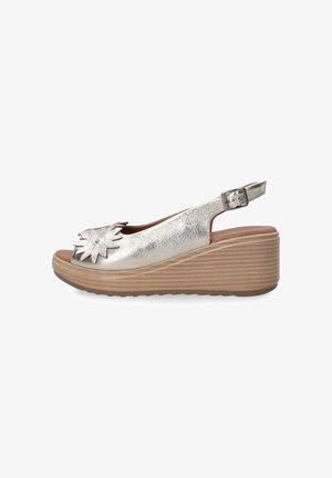 Sandales à talon compensé en argent métallique avec une ouverture à l'avant, présentant un accent floral à l'avant et une sangle réglable à l'arrière. Semelle texturée.