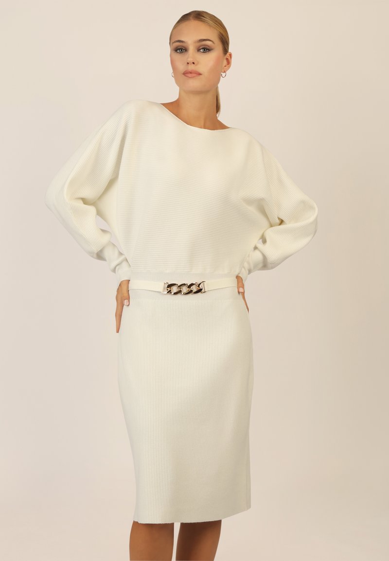 Weißes geripptes Kleid mit weitem Ausschnitt und langen Ärmeln. Hat eine figurbetonte Silhouette und einen Gürtel mit einem goldenen Kettenakzent in der Taille.