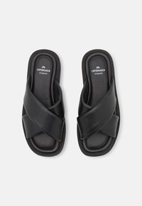 Sandali estivi neri in pelle, con design a fascette incrociate, soletta imbottita e punta arrotondata. La soletta presenta un logo con "COPENHAGEN STUDIOS."