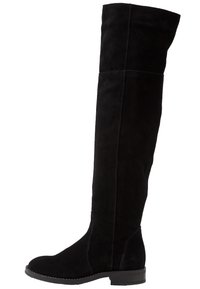 Bottes cuissardes en daim noir avec une semelle plate, un design épuré et des coutures minimales. Matériau texturé avec une finition lisse.