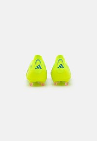 Bright yellow soccer cleats with a textured upper, featuring a blue logo accent and clear pink-tipped studs on the sole.