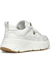 Zapatilla de cuero blanco con suela gruesa, cuerpo texturizado y costuras sutiles. Presenta detalles metálicos dorados y una lengüeta acolchada.