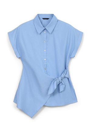 Blouse bleu clair avec col, manches courtes retroussées, fermeture à boutons sur le devant et ourlet asymétrique. Présente un accent noué à la taille.