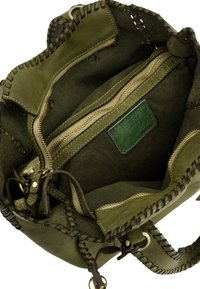 Groene leren handtas met verfijnde stikdetails, voorzien van een met rits afgesloten compartiment en een gladde binnenkant.