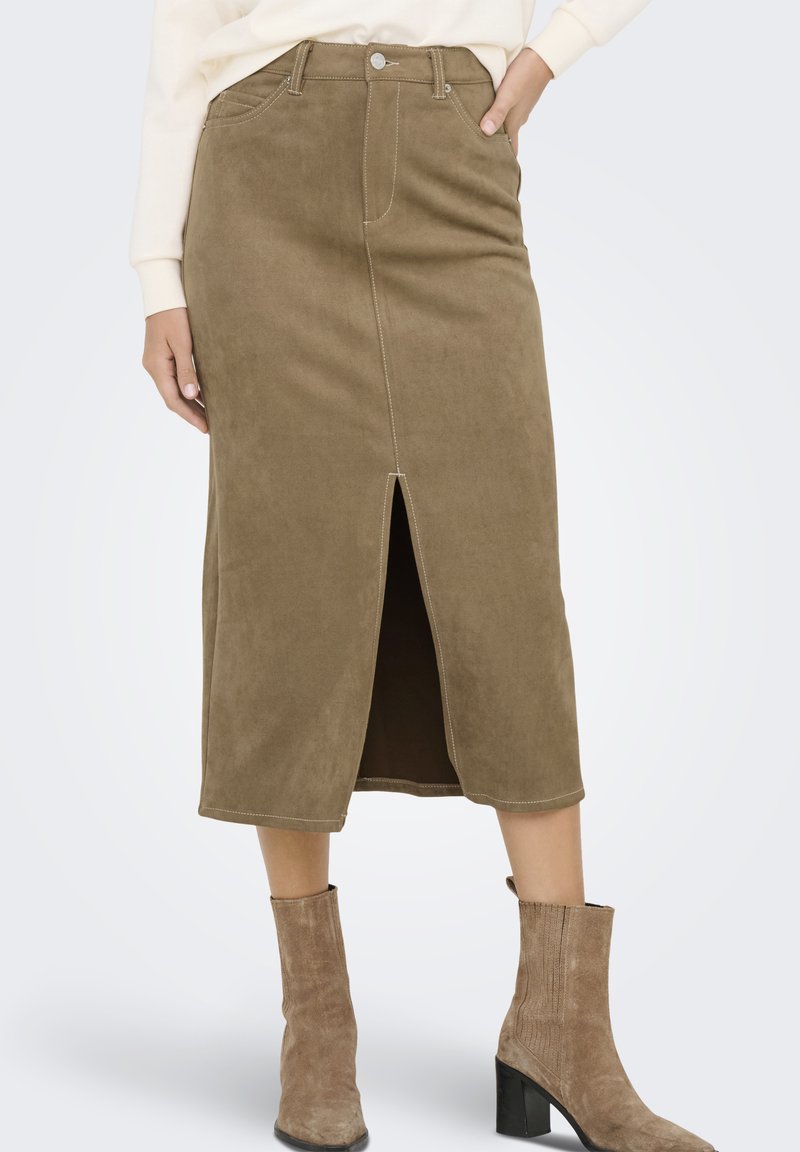 Falda midi de ante color caqui con una abertura frontal, costuras en contraste y un diseño clásico de cinco bolsillos. Combinada con botas de tacón beige.