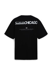 T-shirt in cotone nero con audace testo bianco sul retro: "Southside CHICAGO," "1985," e ulteriore testo descrittivo sulla scena musicale.