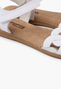 Witte leren sandalen met een geweven bandontwerp, suède accenten en een bruine gevoerde zool. Licht textuur met open tenen en een platte hak.